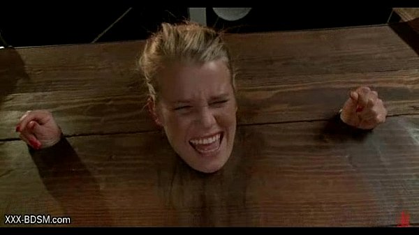 Blonde in wooden clamps gets pussy stimulation