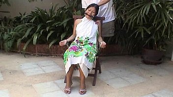 Asian teen tied up and hand cuffed on a chair